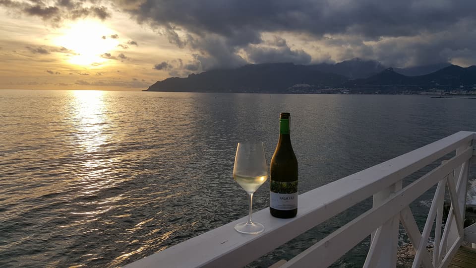 Calice di vino sul terrazzo Miramare davanti al mare di Salerno