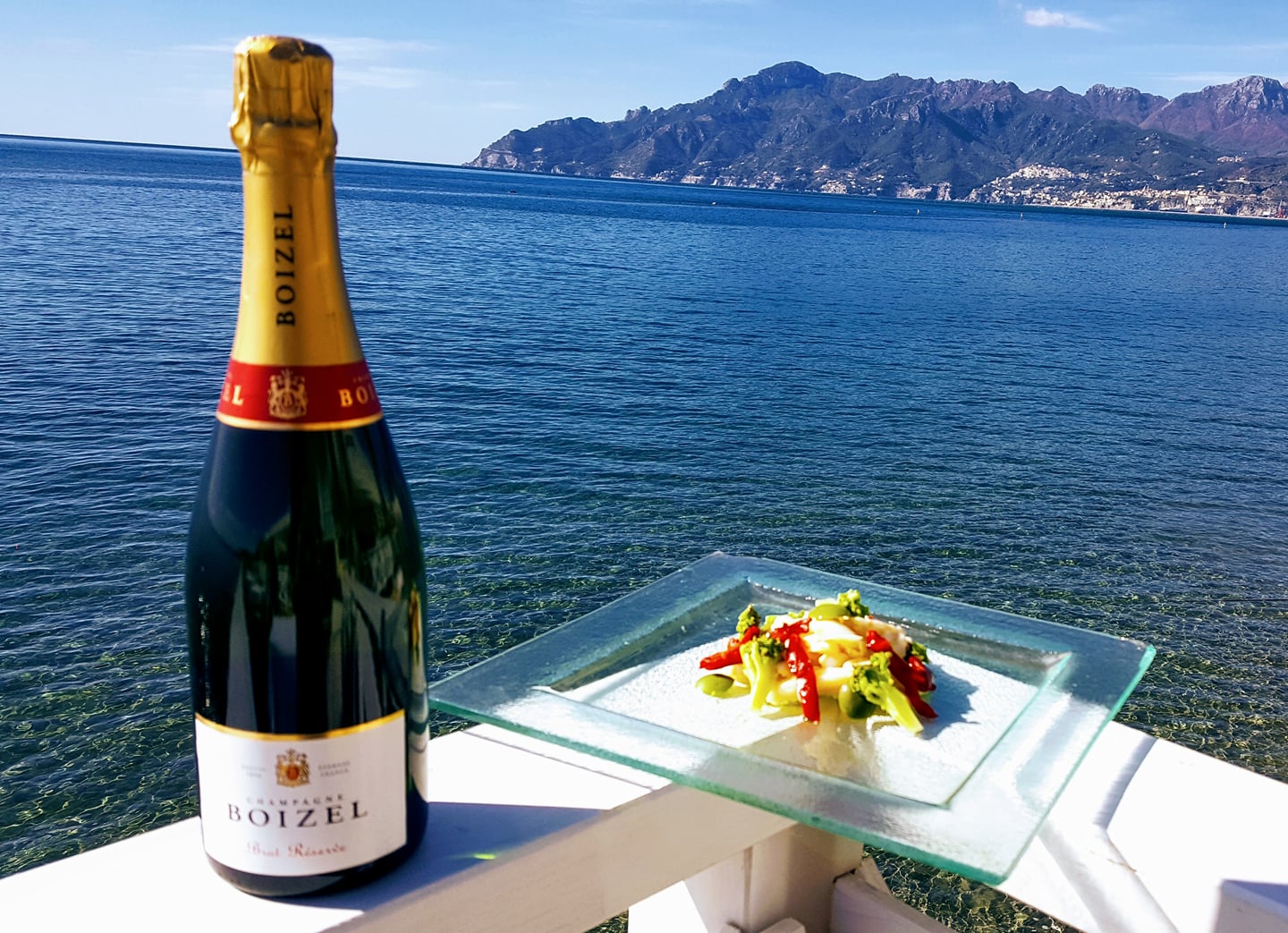 Champagne e piatto gourmet con vista sulla Costiera