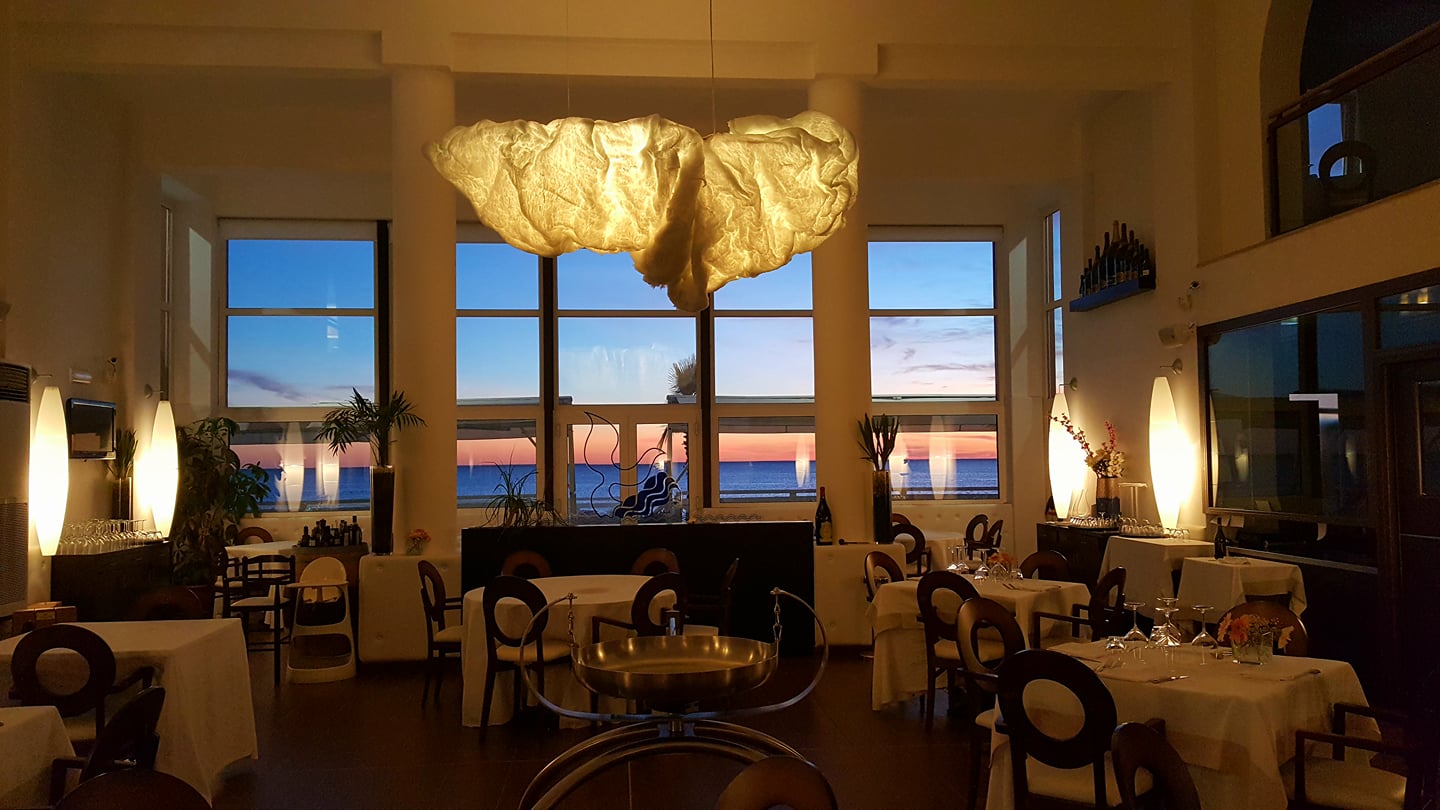 Sala interna elegante del Ristorante Miramare con vista mare al tramonto